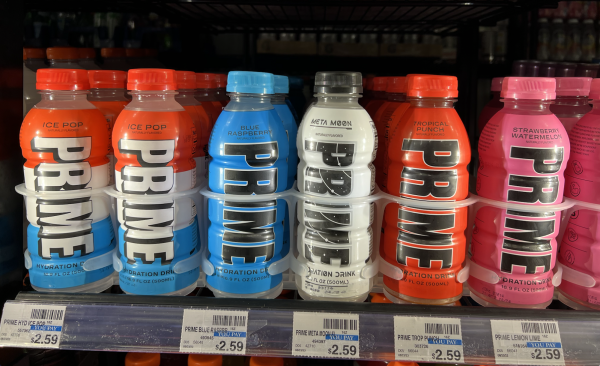 Different flavors of Prime Hydration sit in the fridge of a CVS. Prime bottles are colorful and feature large, chunky text which can be appealing to young adults. Flavor names like Ice Pop and Blue Raspberry are enticing to young palates as well.